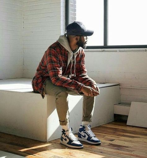 A man sitting inside, while also showing off his flashy blue shoes.