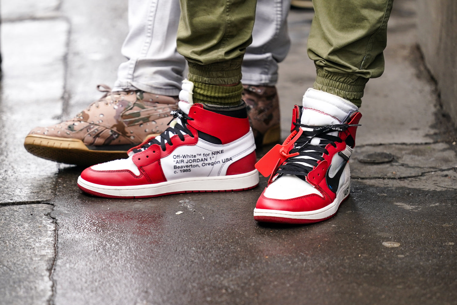 A group of friends standing on the street showing off their "Off-White" shoes.